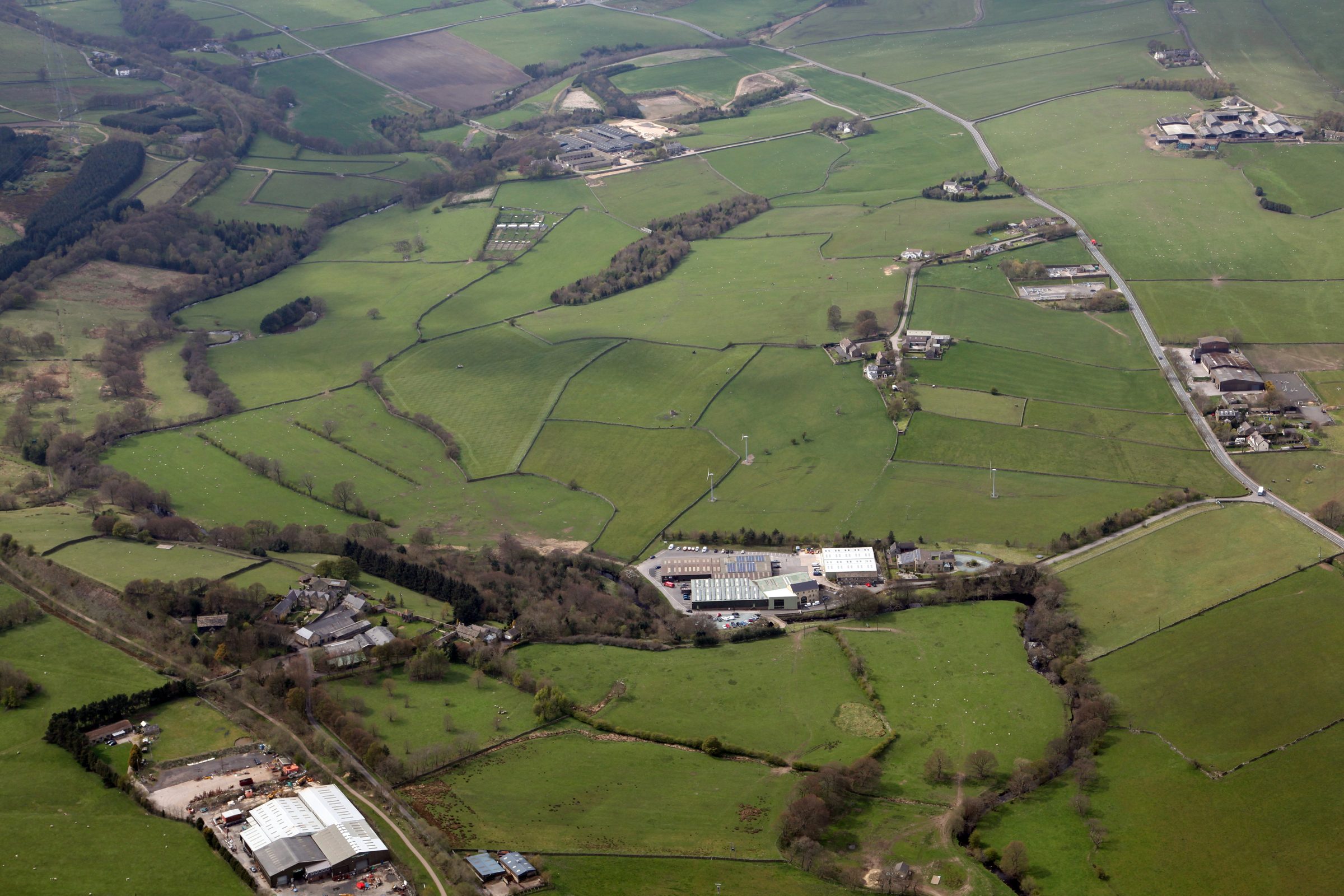 Aerial view of the Bullhouse Mill estate in the valley, surrounded by fields and woodland