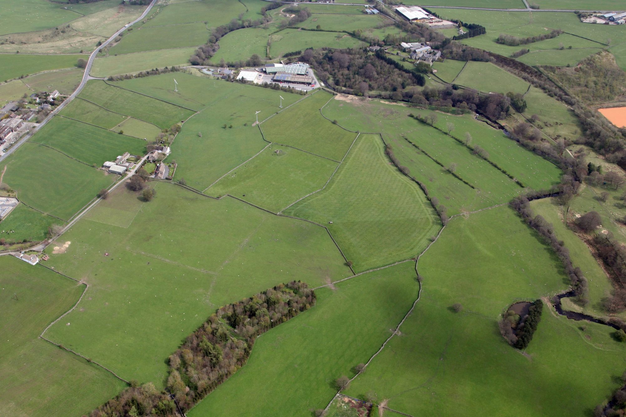 Aerial view of the fields, dry-stone walls, woodland and river surrounding Bullhouse Mill