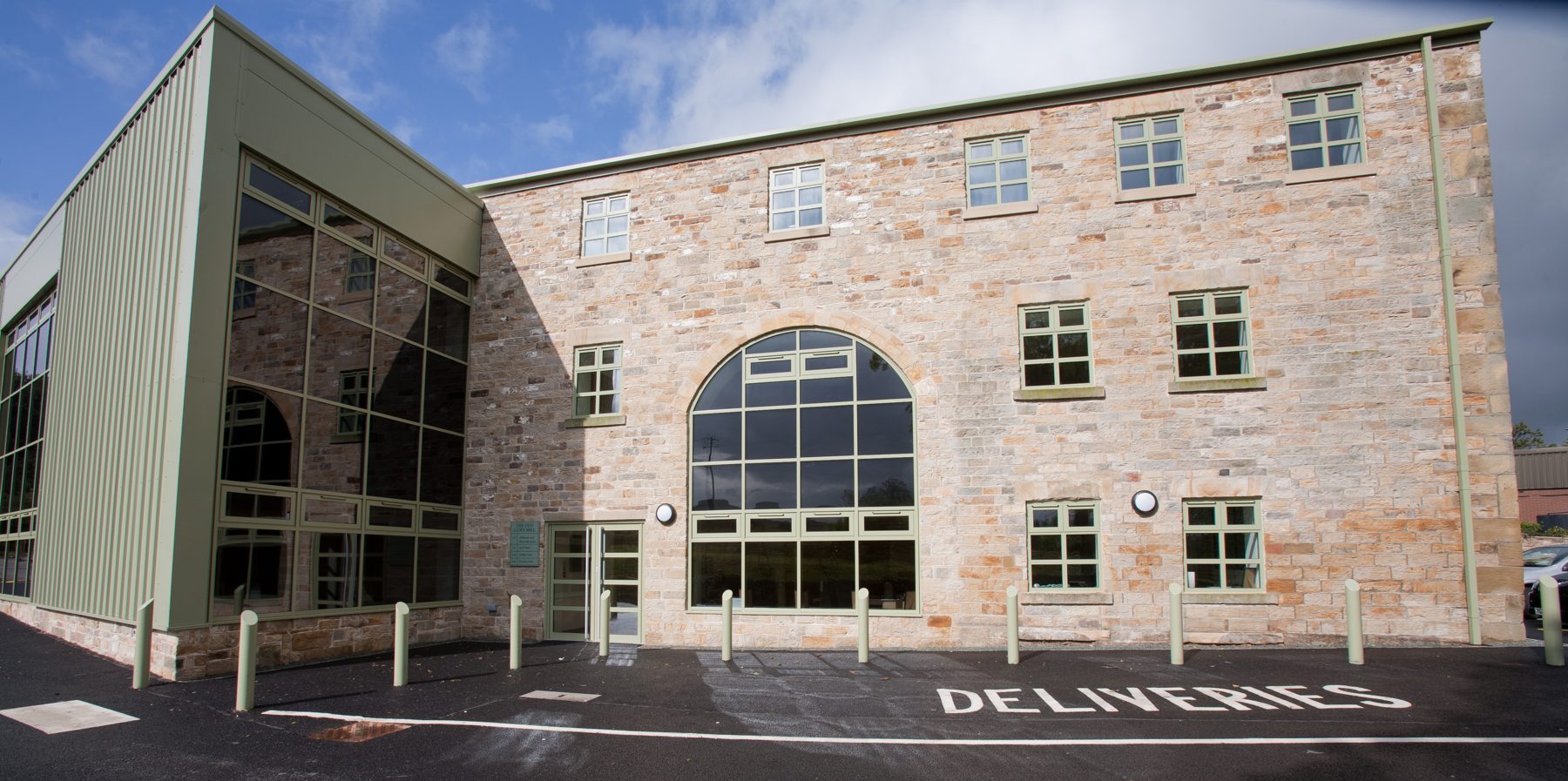The Old Corn Mill, a restored stone mill building with a large arched window