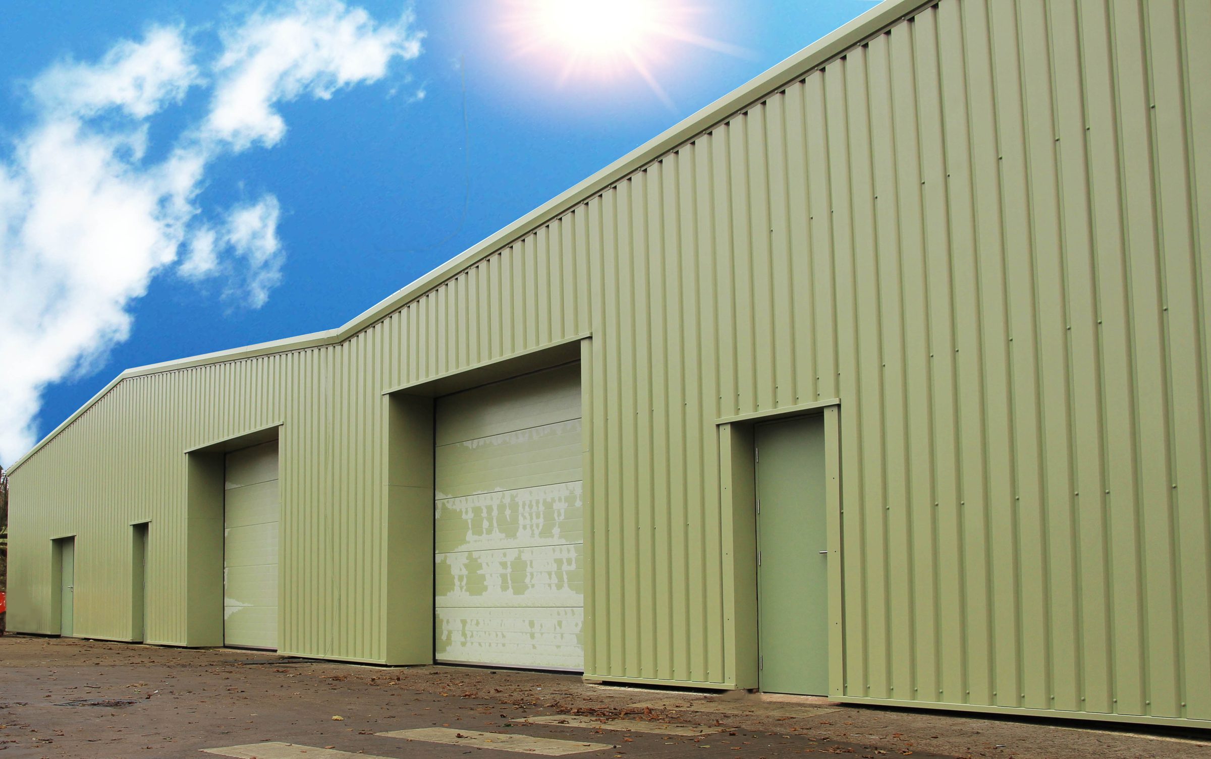 Modern green-clad industrial units with roller doors